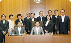 明和町議場を会場に、明和町議会議員全員が写っている