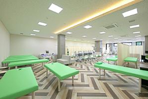 明和石田整形外科・皮膚科クリニックの待合室の画像。緑の椅子が一定方向で並べられている。