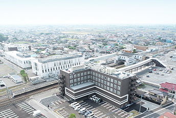明和町の空撮画像。手前に東武伊勢崎線の川俣駅があり、その向こうに街並みがつらなっている。