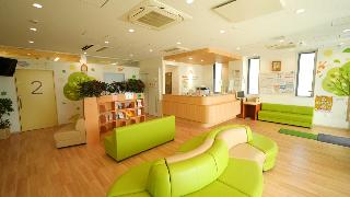 明和赤ちゃんこどもクリニックの内部の様子。木目の床に緑色のソファが置いてあり清潔さが伝わる。