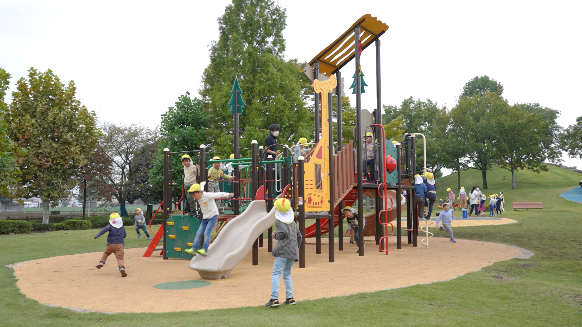 公園のジャングルジムで大勢のこどもが遊んでいる