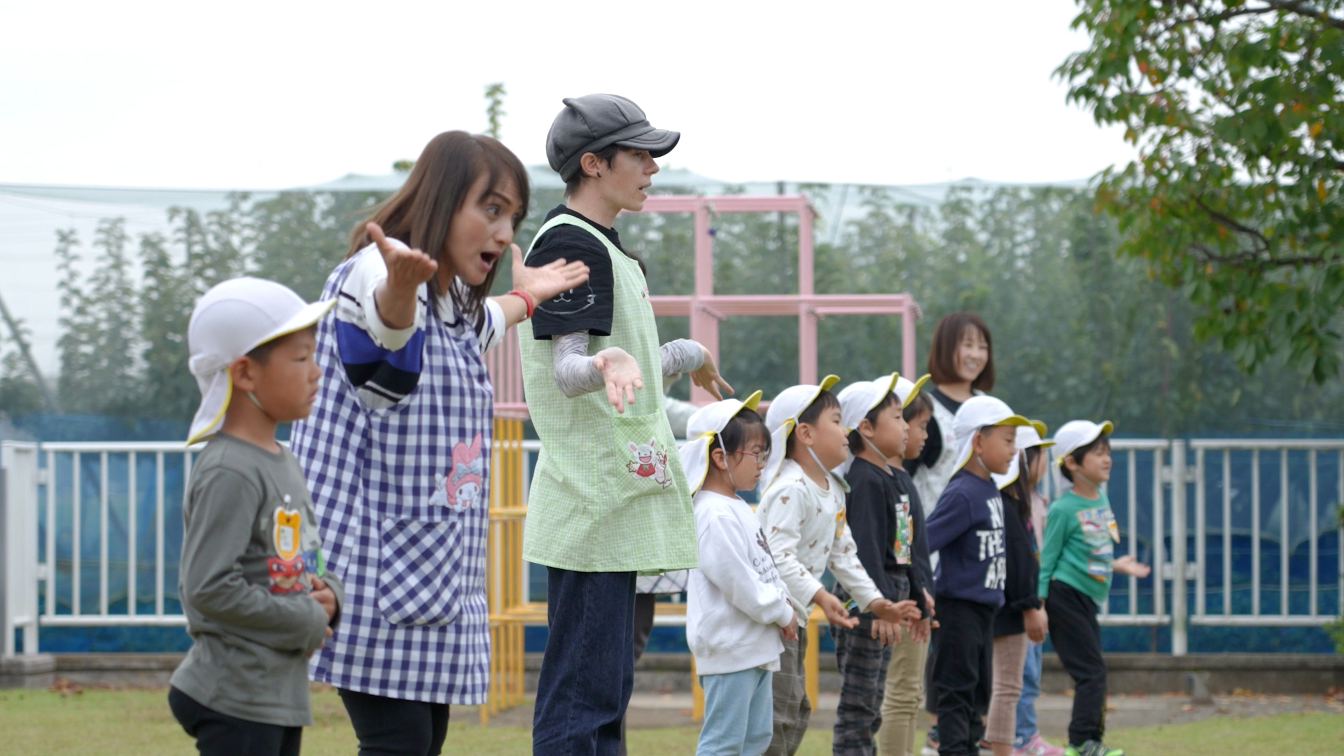 認定こども園「明和こども園」で、先生と園児が1列に並んで手を広げている様子