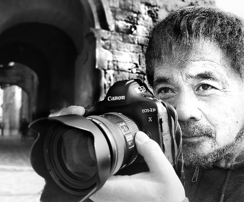 写真家の野村誠一さんがカメラを構えている