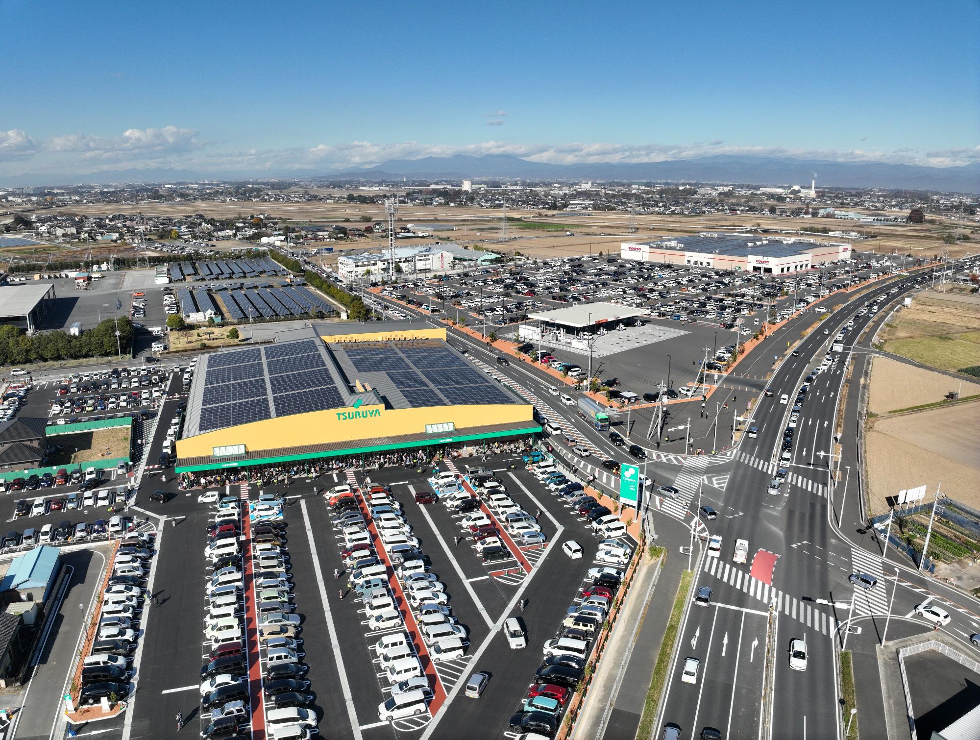 明和町の空撮画像。国道122号線が北に伸び、スーマーケット「ツルヤ」と大型倉庫店「コストコ群馬明和倉庫店」が隣接している。